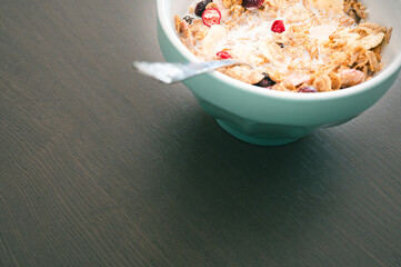 Bowl of muesli isolated on dark wooden background. Fresh oats with fruits and milk for healthy breakfast.
