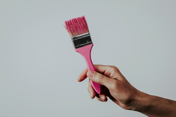 man grabbing a paintbrush with pink paint