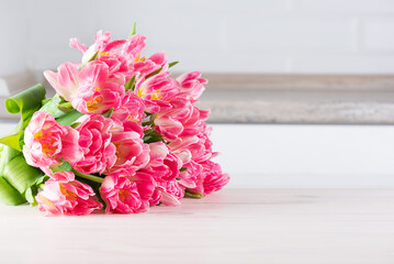 Bouquet of pink tulips on a wooden table. Horizontal orientation, copy space.