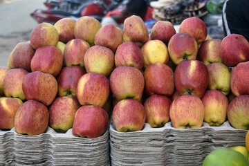 Red and green apples on the market counter. Apples in the cardboard boxes on the grocery shelf.