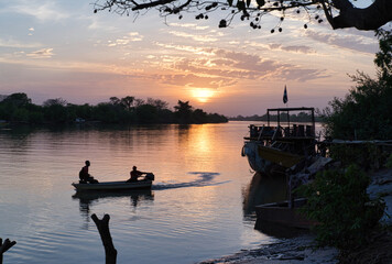 Sunset over river Gambia with fisher boat in front