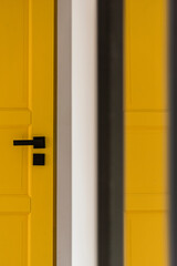 Detal na zółte drzwi i czarną klamke - obrazy, fototapety, plakaty
