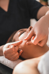 a young brunette girl gets a facial massage in an aesthetic salon. Close shot. the concept of skin care in a beauty salon.