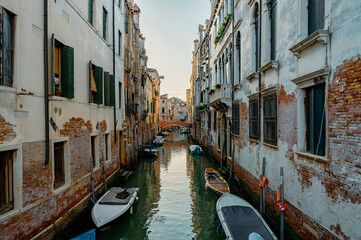 Fototapeta na wymiar Venice, Italy - July 28 2021: Narrow canals with boats and gondolas in Venice, Italy