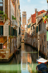 Venice, Italy - July 28 2021: Narrow canals with boats and gondolas in Venice, Italy - obrazy, fototapety, plakaty