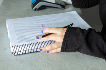 Mujer escribiendo en un cuaderno con un lapicero