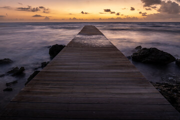 Pier at sunset on a beach