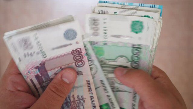 Male Hands Count Money, the Currency is the Russian Ruble. Economy and Finance, Investments. Paper Banknotes. Close-up, Unrecognizable Person, Top View. 