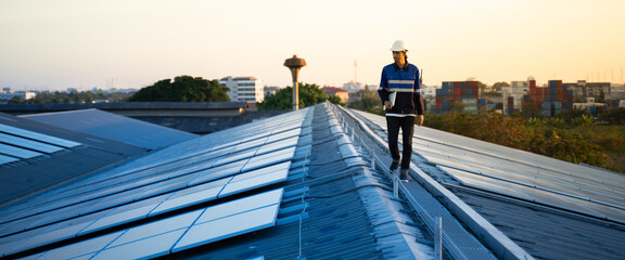 Engineers team survey check solar panel roof.Technician professional engineer with labtop and tablet maintenance checking installing solar roof panel on the factory rooftop under sunlight. © Yingyaipumi