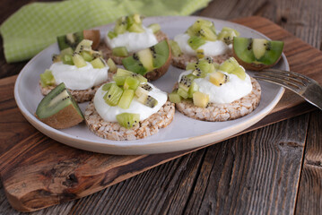 Healthy fitness breakfast plate with chopped kiwis, skyr and brown rice cracker