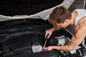 Fototapeta na wymiar Close Up Shot of a Professional Mechanic Working on Vehicle in Car Service.