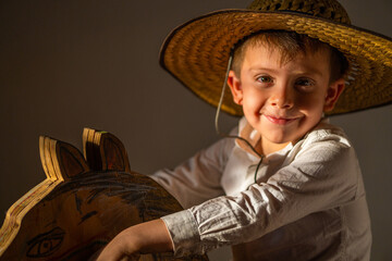 Niño juguetón feliz sonriente expresivo posando con sombrero campesino vaquero disfrutando expresiones emociones alegría y felicidad
