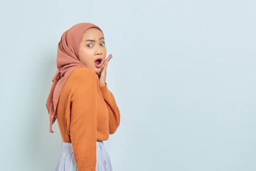 Portrait of surprised young Asian Muslim woman with open mouth and looking at camera isolated on white background