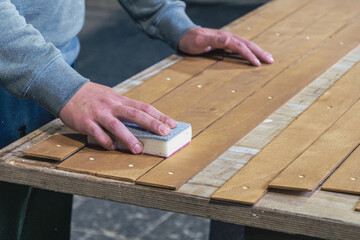 grinding wooden slats by hand in a workshop