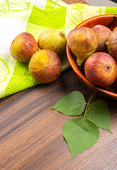 Freshly ripe figs. Healthy Mediterranean fig fruit. Fresh figs on a dark background. Beautiful blue violet figs with leaves, copy space, closeup