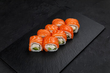 Japanese cuisine. Rolls on a dark concrete background
