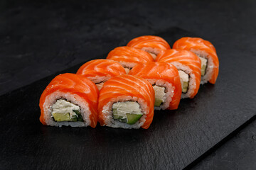 Japanese cuisine. Rolls on a dark concrete background
