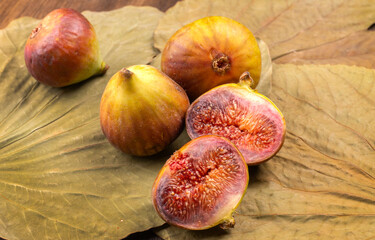 Freshly ripe figs. Healthy Mediterranean fig fruit. Fresh figs on a dark background. Beautiful blue violet figs with leaves, copy space, closeup