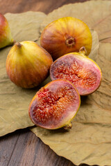 Freshly ripe figs. Healthy Mediterranean fig fruit. Fresh figs on a dark background. Beautiful blue violet figs with leaves, copy space, closeup