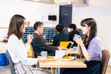 オフィスのカフェテリアのランチを食べる社員