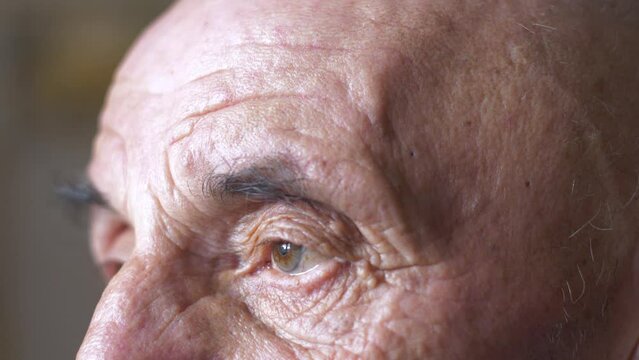 Close-up of the eyes of a caucasian pensioner with a sad look. Part of the face of an elderly man 70 years old. Wrinkles near the eyes.Selective focus