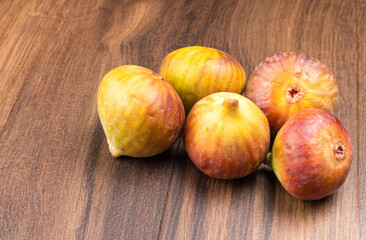 Freshly ripe figs. Healthy Mediterranean fig fruit. Fresh figs on a dark background. Beautiful blue violet figs with leaves, copy space, closeup