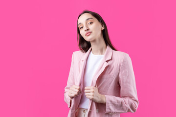 Portrait of beautiful young woman in pink jacket thinking isolated on red background