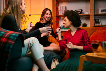 A group of young multiracial women having a girl's night at home. They are having a party and...