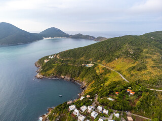 Amazing sunset on a paradise beach with mountains, nature and city. Drone aerial view. Arraial do Cabo, Rio de Janeiro, Brazil