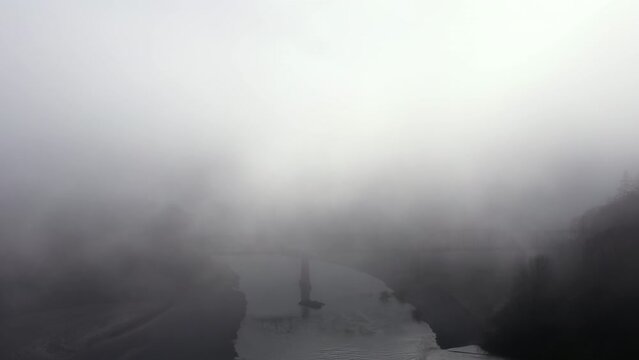 Train Trestle bridge shrouded in fog, aerial view.