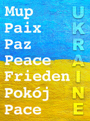 word Peace in several languages on Ukrainian flag painted on wall