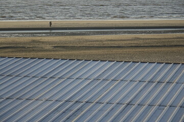 Grey metal roof of beach hut over sandy North Sea beach, use: background, copy space (horizontal),...