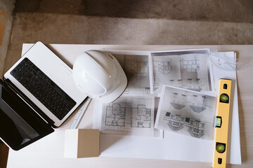 Fototapeta na wymiar blueprints, protective helmet, laptop,house model and tools on architect workspace.Construction site