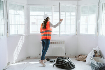 inspector or architect professional woman checking windows at construction site. Home improvement