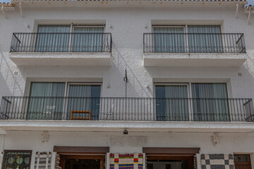 Facade of a white mediterranean tourist building with a shop on the ground floor