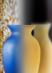 blue and orange glass vase and plant with leaves