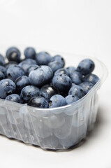 Owoce borówki wysokiej amerykańskiej ułożone w plastikowym przezroczystym pojemniczku © Katarzyna