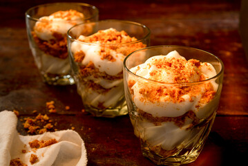 three glasses filled with yogurt and crumbled cookies