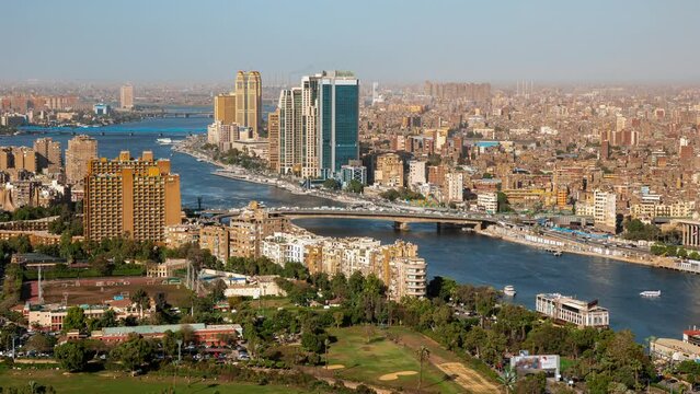 Top view of modern Cairo, river Nile, island Gezira. Timelapse. Daily life in capital of Egypt with buildings, trees, skyscrapers, cars, boats. Transport moving, ships sailing, people going