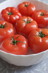 red tomatoes in a white plate on the table