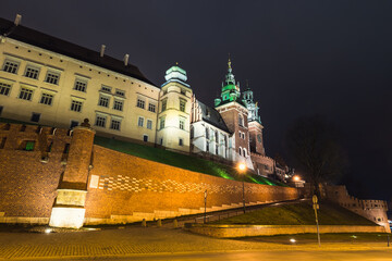Fototapeta na wymiar Wawel Royal Castle at night in Krakow, Poland. View from the Kanonicza street.