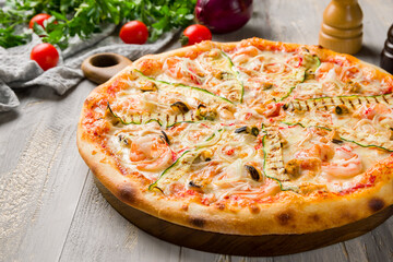 pizza with shrimps, cheese and zucchini  on grey wooden table macro close up