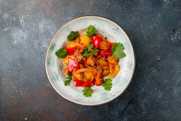 Pork in sweet and sour sauce with fried vegetables on plate top view