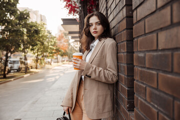 Young business woman holding coffee of the modern office building background 