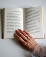 Naklejka premium person reading a book on a table