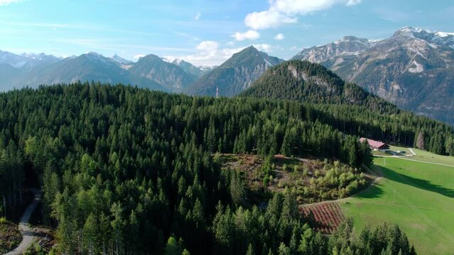 Drone shot of a beautiful alpine landscape with forested mountain tops. Aerial view of natural scenery in Tyrol, Austria.