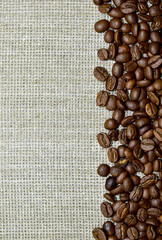 Coffee beans scattered on burlap, top view, close-up, place for text