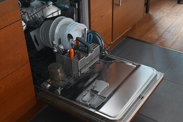 Open dishwasher with dirty dishes in a brown kitchen