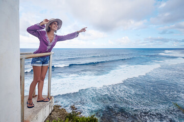 Tourism concept. Young traveling woman enjoying ocean view.