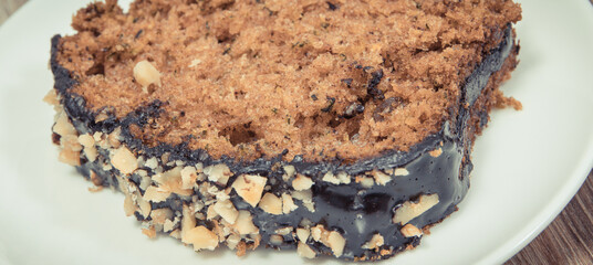 Homemade pastry made of zucchini with nuts and raisin. Wooden background